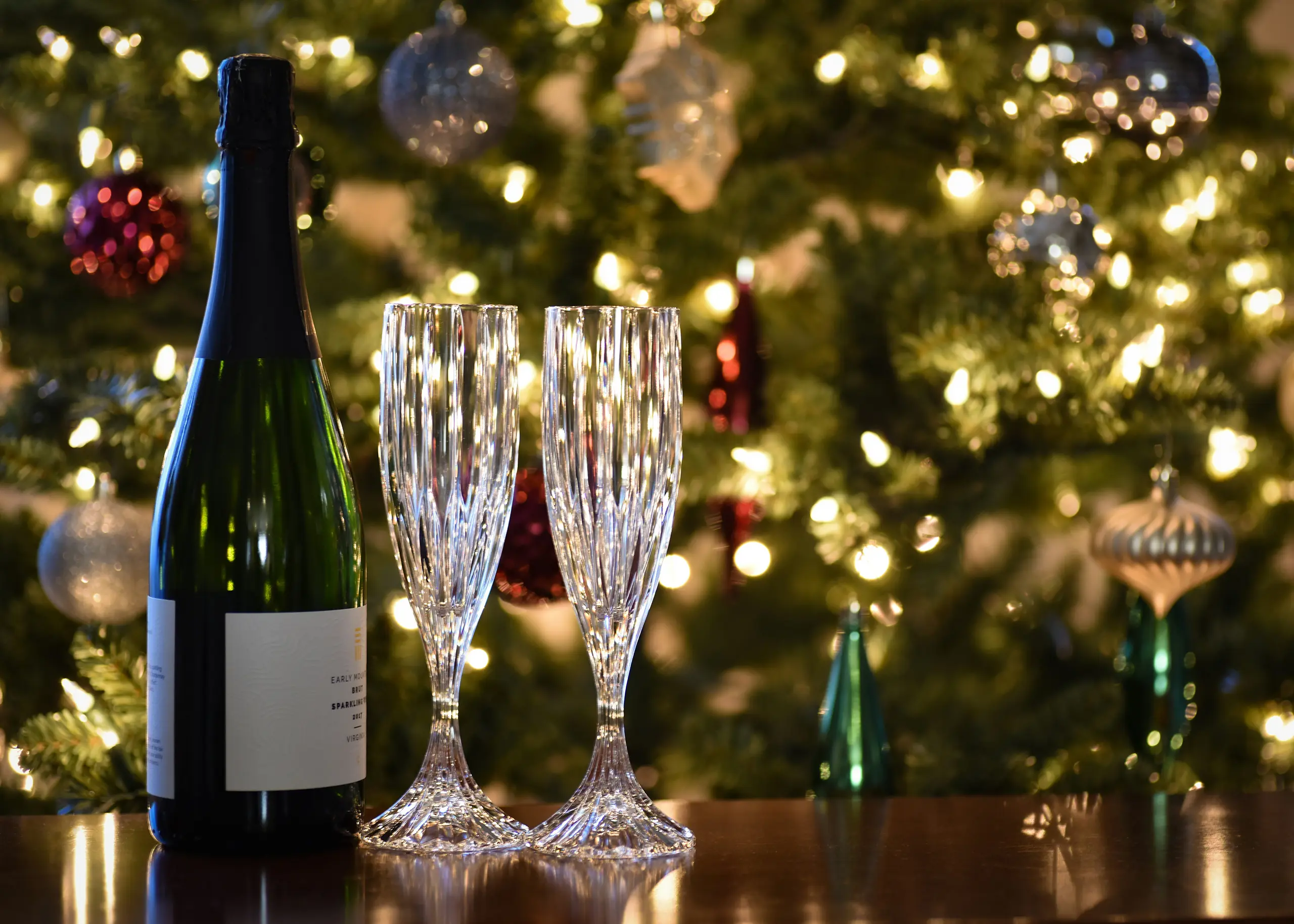 christmas wine and glasses in front of tree