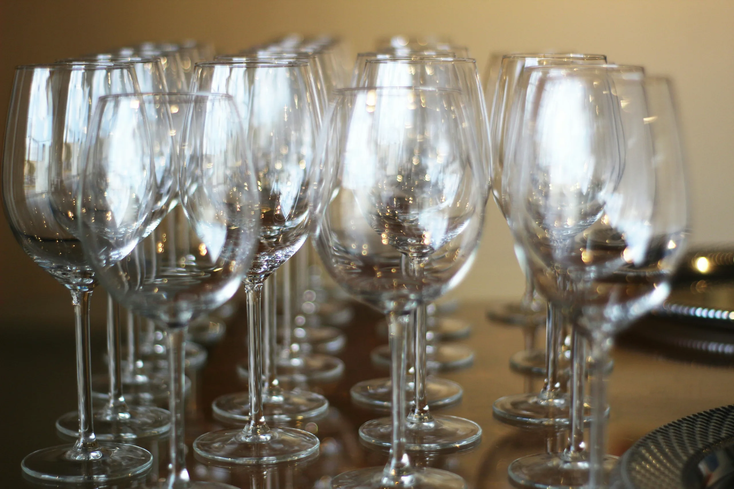 wine glasses on bar top near plates